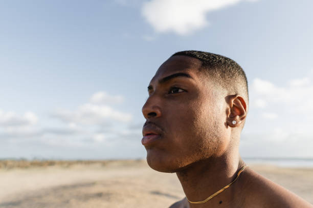 istock Young athletic man gazing towards ocean on beach 2170742663