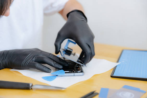 istock A young man repairs a smartphone at home. 2170743235