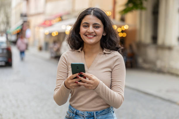 istock Indian woman use smartphone typing text messages browsing internet finishing work looking at camera 2170747517