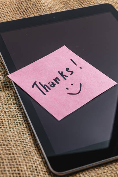 Pink thank you note on tablet screen on knitted background High quality photo