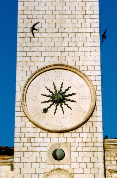 Ancient tower of light color with large round clock