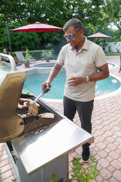 istock Man cooking on a barbecue by the pool 2170759140