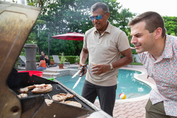 istock Two men cooking on a barbecue grill by the pool 2170759192