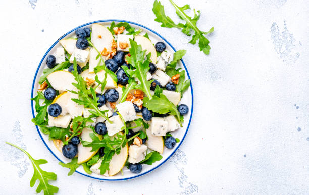 istock Gourmet salad with pears, blueberries, gorgonzola cheese, arugula and walnuts. White background, top view 2170759700