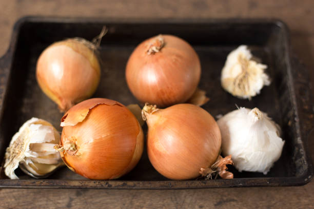 Garlic Bulbs and Yellow Onions in Old Pan