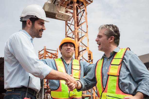 istock Team of workers at construction site with heavy machines. 2170761269