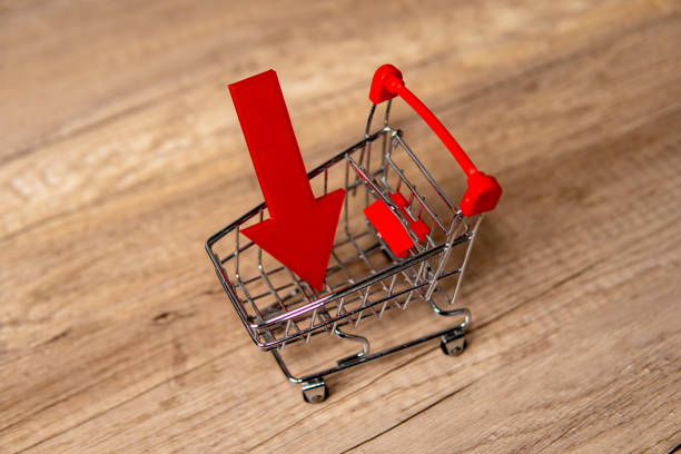 istock A miniature shopping cart with downward-pointing red arrow. 2170770700