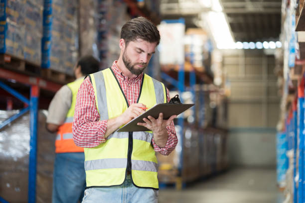 istock Warehouse concept. Two male warehouse worker working and checking boxes of products on shelf in warehouse. Group of two male worker at warehouse 2170772075
