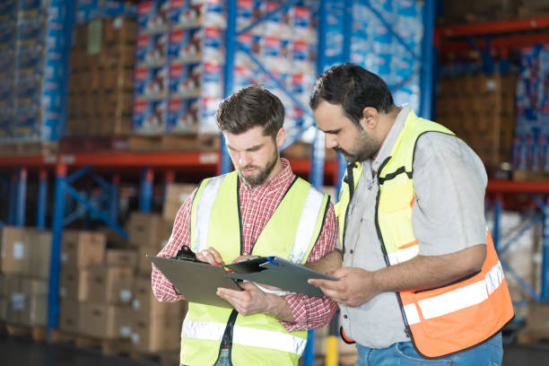 istock Warehouse concept. Two male warehouse worker working and checking boxes of products on shelf in warehouse. Group of two male worker at warehouse 2170772122
