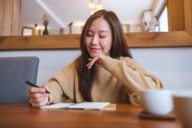 istock Portrait image of a young woman writing on a notebook on the table 2170772386