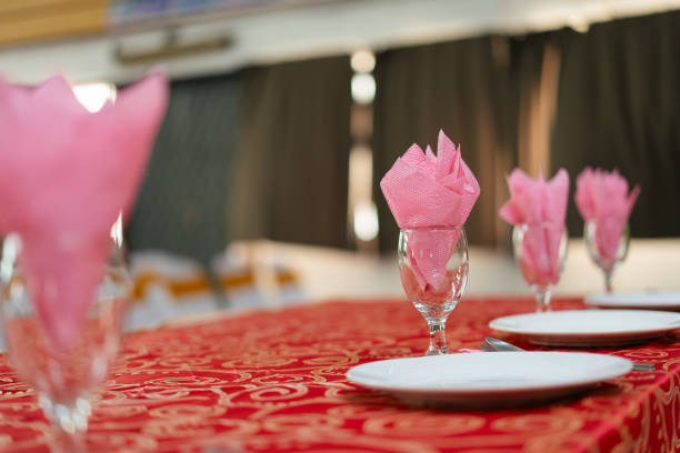 Wine glass decorated with a pink serviette, prepared for a dining setup.