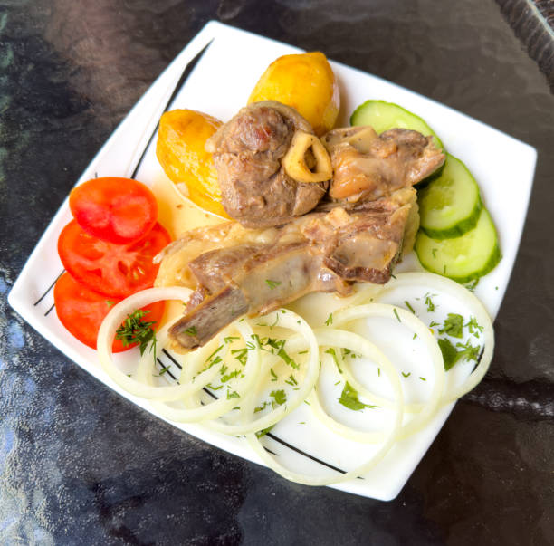 Close-up of delicious juicy meat baked in the oven with vegetables and decorated with fresh herbs. Food background