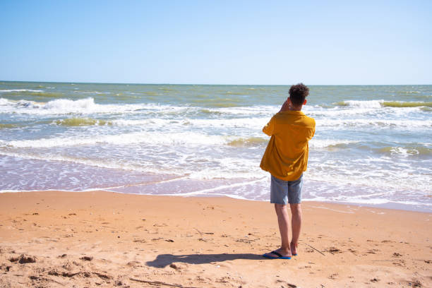 istock A young attractive man relaxes and studies by the sea. 2170778289