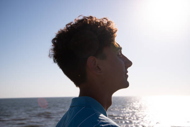 istock A young attractive guy is walking on the beach. 2170780177
