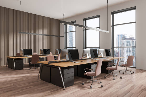 istock Stylish coworking interior with armchairs and desks, pc monitors and window 2170782745