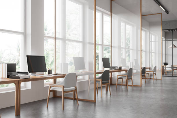 istock Office interior with pc computers and desks in row, dividers and window 2170783145