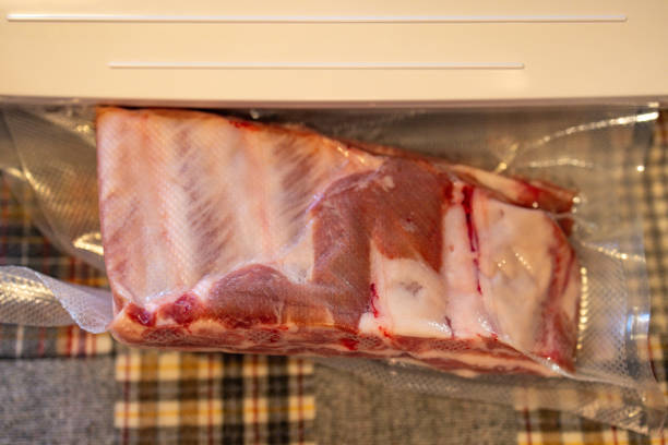istock Vacuum sealing pork ribs into a plastic bag for freezing 2170783701