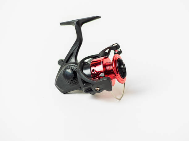 istock A red and black fishing reel sits on a white background 2170785611