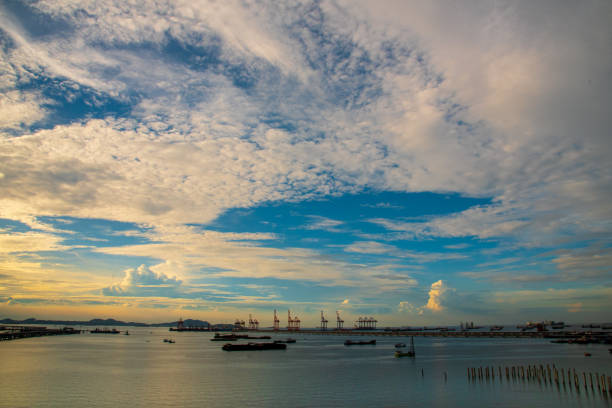 Logistic shipping quay boat in twilight sky night Engineering crane depot at logistic export terminal control. Warehouse freight background container yard loading quayside harbor port Logistics.