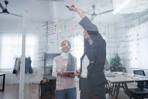 istock A diverse team of professionals collaborates on a project while working at a whiteboard in a modern office setting 2170787656