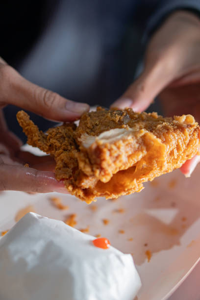 istock Close-Up of Crispy Fried Chicken in Hands 2170795031