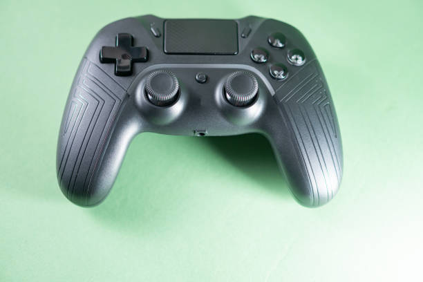 istock Close-Up of Black Gaming Controller on Green Background 2170795731