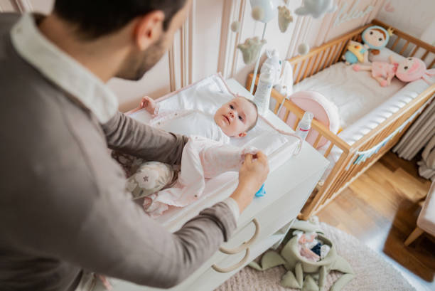 istock Father changing his daughter's clothes at home 2170795740