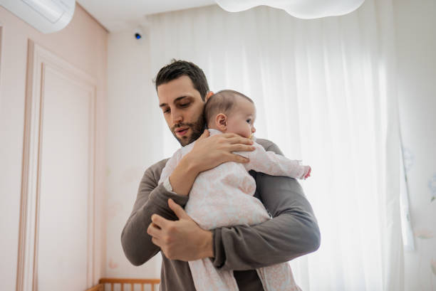 istock Father with daughter on his lap at home 2170796091