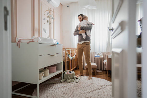 istock Father with daughter on his lap at home 2170796096