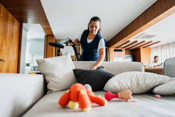 istock Housekeeper vacuuming sofa in a house 2170797606