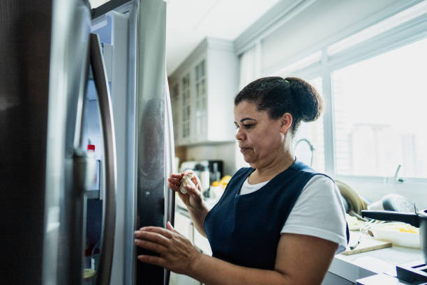 istock Housekeeper using the refrigerator in a domestic kitchen 2170797620