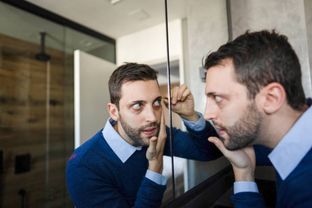 istock Mid adult man removing eyebrows in bathroom 2170798712