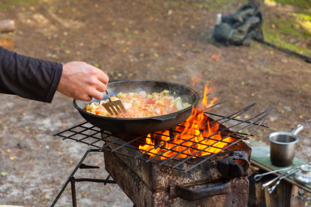 istock A man mixes potatoes, tomatoes and peppers in a frying pan 2170802736