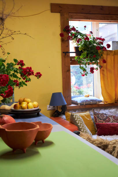 design interior of a creative workshop in yellow and blue tones, with an orange sofa and colorful cushions