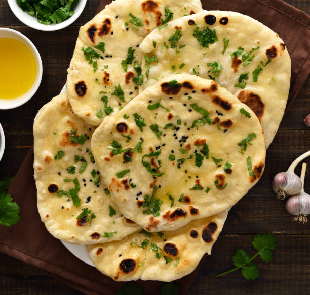 istock Indian naan bread over wooden background 2170806270