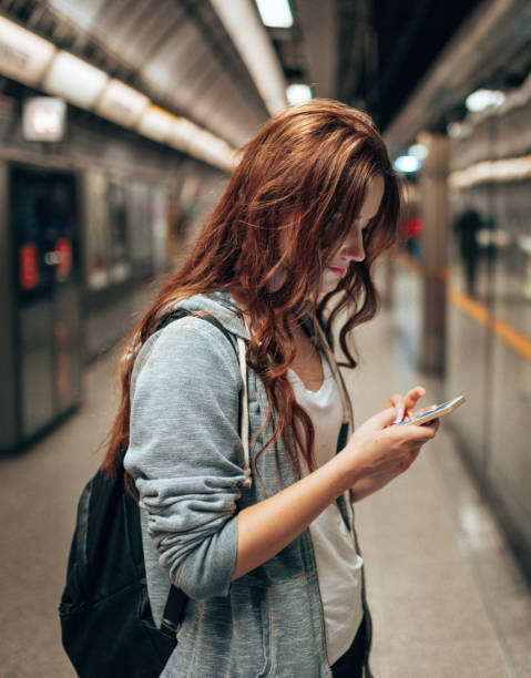 young woman using social media waiting the metro train