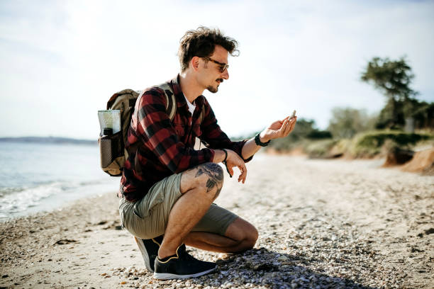 istock Man collects seashells in the sand 2170816998