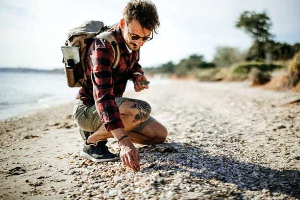 istock Man collects seashells in the sand 2170817004