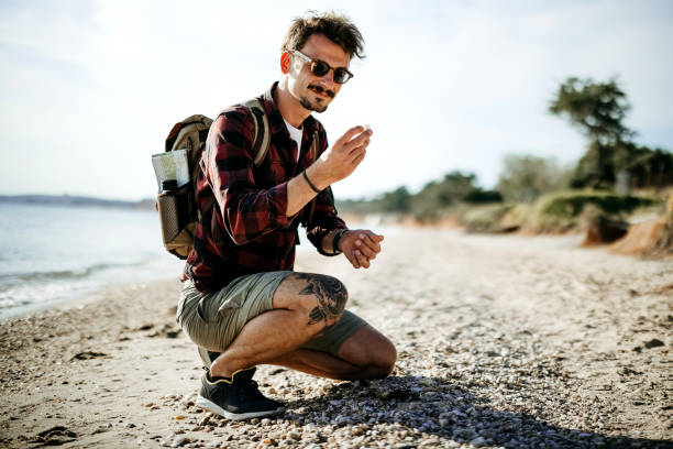 Man collects seashells in the sand on the beach