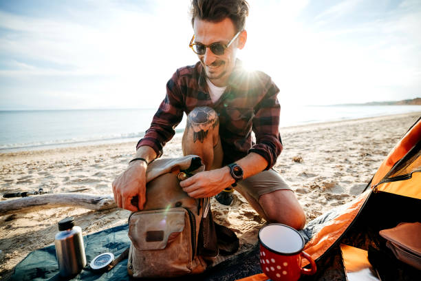 istock Man cooking coffee at sea sandy beach. 2170817135
