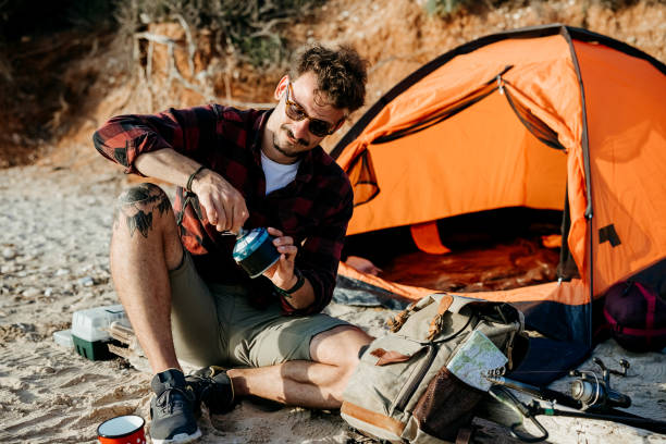 istock Man cooking coffee at sea sandy beach. 2170817137
