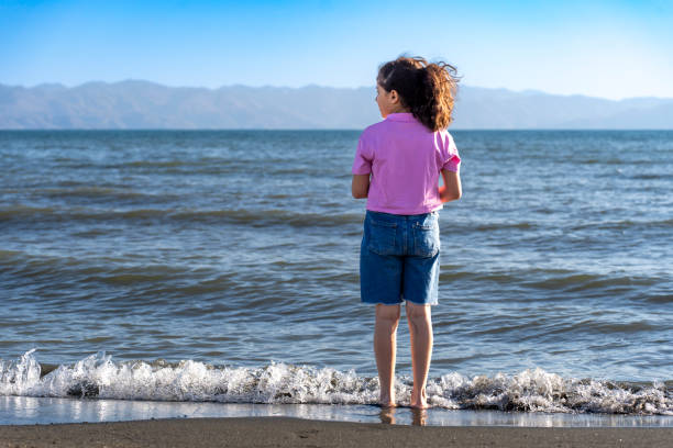 Girl child spending time by the sea. Fun activity. Boy playing games on the beach.