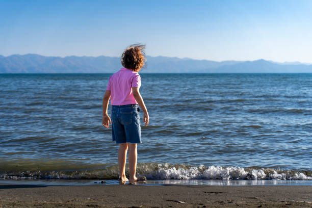 Girl child spending time by the sea. Fun activity. Boy playing games on the beach.