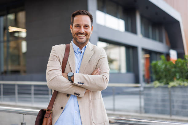 istock Man smiles confidently with arms crossed outside office. 2170817630
