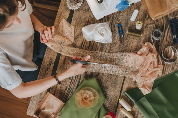 istock Top view of female tailor cutting lace with scissors making handmade decor 2170820276