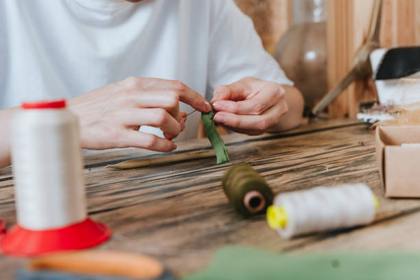 istock Female tailor sewing sitting at the table near sewing machine 2170820368