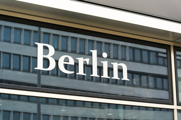 A sign for a U-Bahn Subway station near Berliner Dom, with the cathedral and the city's TV Tower in the background.