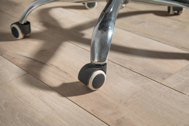 istock Office chair wheels on laminate floor. 2170826314