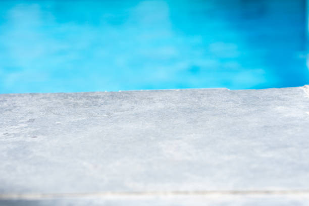 istock Empty grey ceramic table top and blurred swimming pool in tropical resort in summer banner background 2170827187
