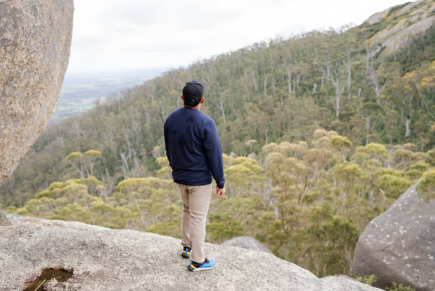 istock A man stands under a large boulder in The Granite Skywalk in Mount Gardner, Mount Manypeaks , Albany 2170828358
